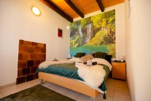 a bedroom with a bed with a painting on the wall at Kuća za odmor Mia 