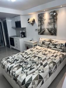 a bedroom with a black and white comforter on a bed at 50 meters by the beach - Maria Paradise in Polychrono