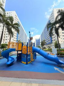 un patio de recreo en un parque con un tobogán en Sea Residences MOA Manila by Paul, en Manila