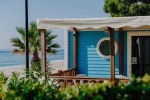 a blue house on the beach with the ocean at Alannia Costa Dorada in Platja de l’Almadrava