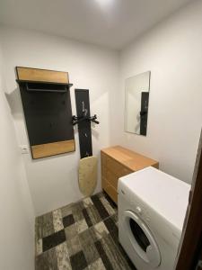 a bathroom with a washing machine and a mirror at Butas Čiurlionio gatvėje in Pakopi