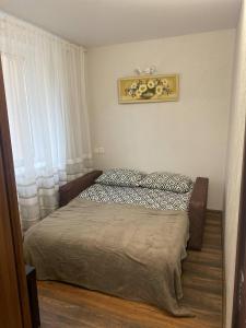 a small bedroom with a bed and a window at Butas Čiurlionio gatvėje in Pakopi