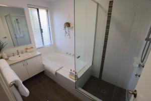 een witte badkamer met douche en wastafel bij Royal-Tee Retreat in Dunsborough +36 foto's