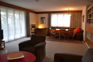 a living room with a table and a dining room at Arcula in Flims