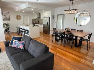 a living room and kitchen with a couch and a table at Royal-Tee Retreat in Dunsborough