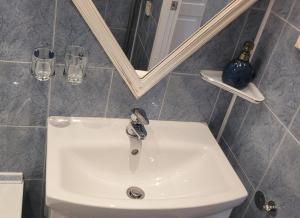 a white sink in a bathroom with a mirror at Vintažys studeja in Rēzekne