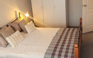 a bedroom with a large bed with a checkered blanket at Vintažys studeja in Rēzekne