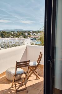 a couple of chairs sitting on a balcony at Luxe villa met privézwembad & zeezicht - Villa Luna in Sant Josep de Sa Talaia