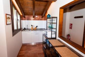 cocina con armarios blancos y techo de madera en La Cabaña, en Robledo