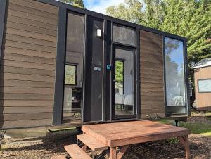 una cabina con un tavolo da picnic in legno di fronte di 2BR Tiny Family Home at Grampians Edge by Tiny Away a Dadswells Bridge