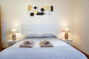 een slaapkamer met een bed met handdoeken erop bij Rosária Flat in Santa Cruz