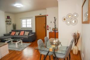 een woonkamer met een glazen tafel en een bank bij Rosária Flat in Santa Cruz