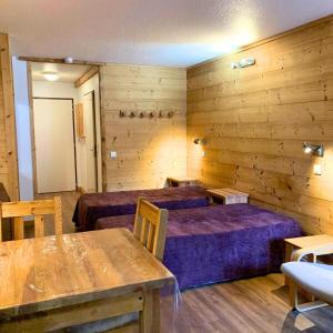 a room with two beds and a table in it at Studio charmant et confortable Brides Les Bains in Brides-les-Bains