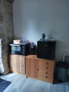a tv on top of a wooden cabinet with a fish tank at Sous un chêne bicentenaire in Lambesc