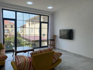 a living room with a couch and a tv at Style Home Buzovna in Baku