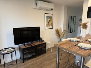 TV a/nebo společenská místnost v ubytování L'Amandier - Joli appartement T3 neuf centre ville à 2 pas de la Rotonde Mirabeau et des Allées Provençales