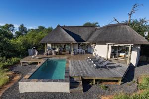 a house with a deck and a swimming pool at Villa Blaaskans in Hoedspruit