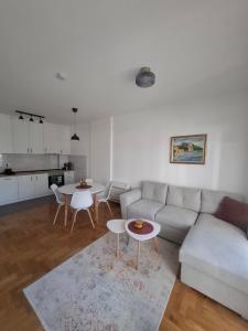 un soggiorno con divano e tavoli e una cucina di Apartman Astra a Trebinje