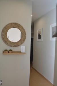 Un pasillo con un espejo redondo en la pared. en Apartamento La Rosa, en El Puerto de Santa María