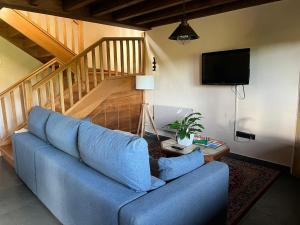 a blue couch in a living room with a tv at Casona Asturiana Casa Delfa in Cervera