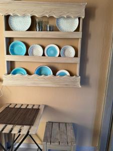 a shelf with plates and bowls on it next to a table at Ethereal studio in Afytos in Afitos +6 photos