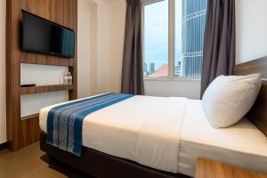 a hotel room with a bed and a television at Hotel 1915 Chinatown Kuala Lumpur in Kuala Lumpur
