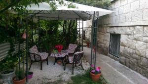 a table and chairs under an umbrella in a garden at Bingo Apartment in Split