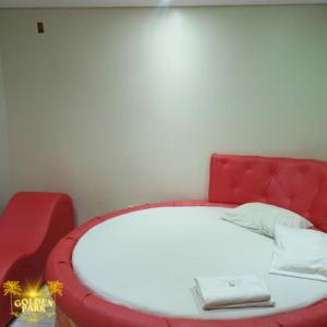 un divano rosso con un letto bianco in una stanza di Golden Park Hotel II a Brasilia