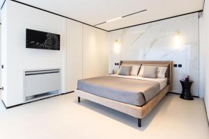 a bedroom with a bed in a white room at Extreme Luxury Villa in Punta Ala with Private Pool, SPA and Gym in Punta Ala +29 photos