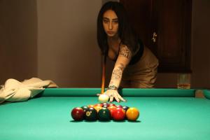 a woman playing pool with a cue on a pool table at I Giardini di Marcello in Dicomano