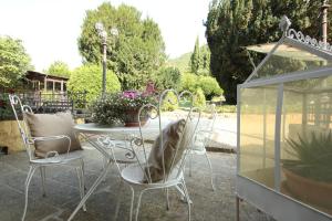 a patio with a table and chairs and a greenhouse at I Giardini di Marcello in Dicomano