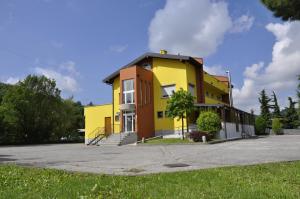 Entratico的住宿－米拉恩雅賓館，一座黄色和橙色的建筑,设有停车场