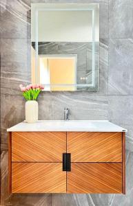 ein Badezimmer mit Waschbecken und Spiegel in der Unterkunft Discover your sanctuary at this townhouse in Plai Laem