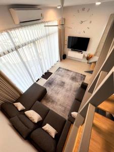 ein Wohnzimmer mit einer schwarzen Couch und einem Fernseher in der Unterkunft Discover your sanctuary at this townhouse in Plai Laem