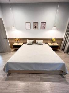 ein großes Bett in einem Zimmer mit 2 Tischen in der Unterkunft Discover your sanctuary at this townhouse in Plai Laem