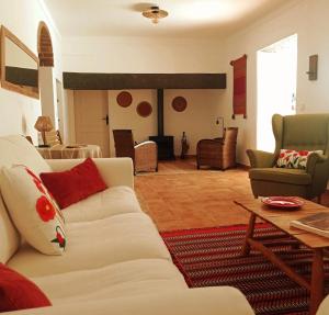 a living room with a white couch and a table at Casa da Vila in Mourão