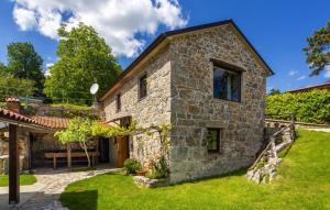 an old stone house with a grass yard at Casa Antica - Storia Verde Opatija in Veprinac