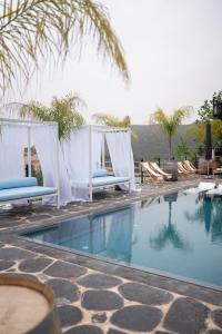 a swimming pool with lounge chairs next to a resort at Doria Luxury Boutique Hotel in Dishon