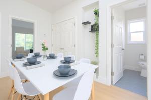 ein weißes Esszimmer mit einem weißen Tisch und Stühlen in der Unterkunft New Build House Laundry Kitchen Airconditation in Sunnyvale