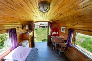 a bedroom and desk in a tiny house at Manoir du Bois Joly - Roulotte Gitane in Margon