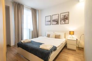 a white bedroom with a bed and a window at Charming & Cozy 1BR Flat in the Heart of Bucharest in Bucharest
