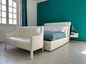 a bedroom with a white bed and a chair at Bed and Breakfast Villa Teis in Quartu SantʼElena +34 photos