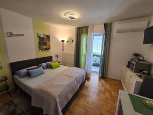 a bedroom with a large bed and a television at Jasna - apartman studio in Pula