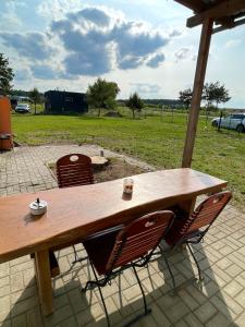 a wooden picnic table with chairs and a field at Das "Alte Jagdhaus" - mit großem Grundstück für 3 Personen in Groß Garz