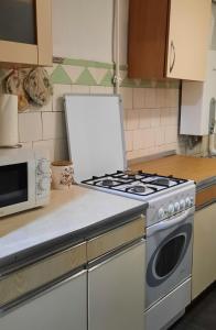 a kitchen with a stove and a microwave at Гостевой дом in Odesa +5 photos