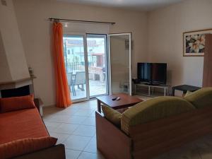 a living room with a couch and a tv at Autonomous Maisonette in Nikiti