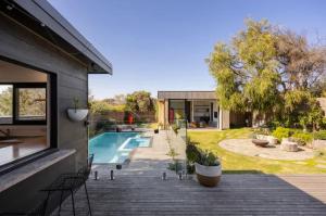 Quay-Walk to beach Gas Heated Pool, Spa, Trampoline في بليرغوري: حديقة خلفية مع حمام سباحة ومنزل