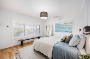 Quay-Walk to beach Gas Heated Pool, Spa, Trampoline في بليرغوري: غرفة نوم بيضاء مع سرير ونافذة