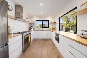 Quay-Walk to beach Gas Heated Pool, Spa, Trampoline في بليرغوري: مطبخ مع دواليب بيضاء ونافذة كبيرة +25 صورة