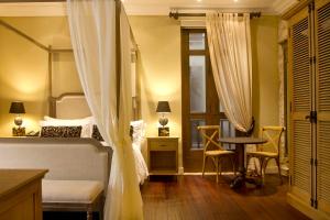 Un pat sau paturi într-o cameră la Bastión Luxury Hotel